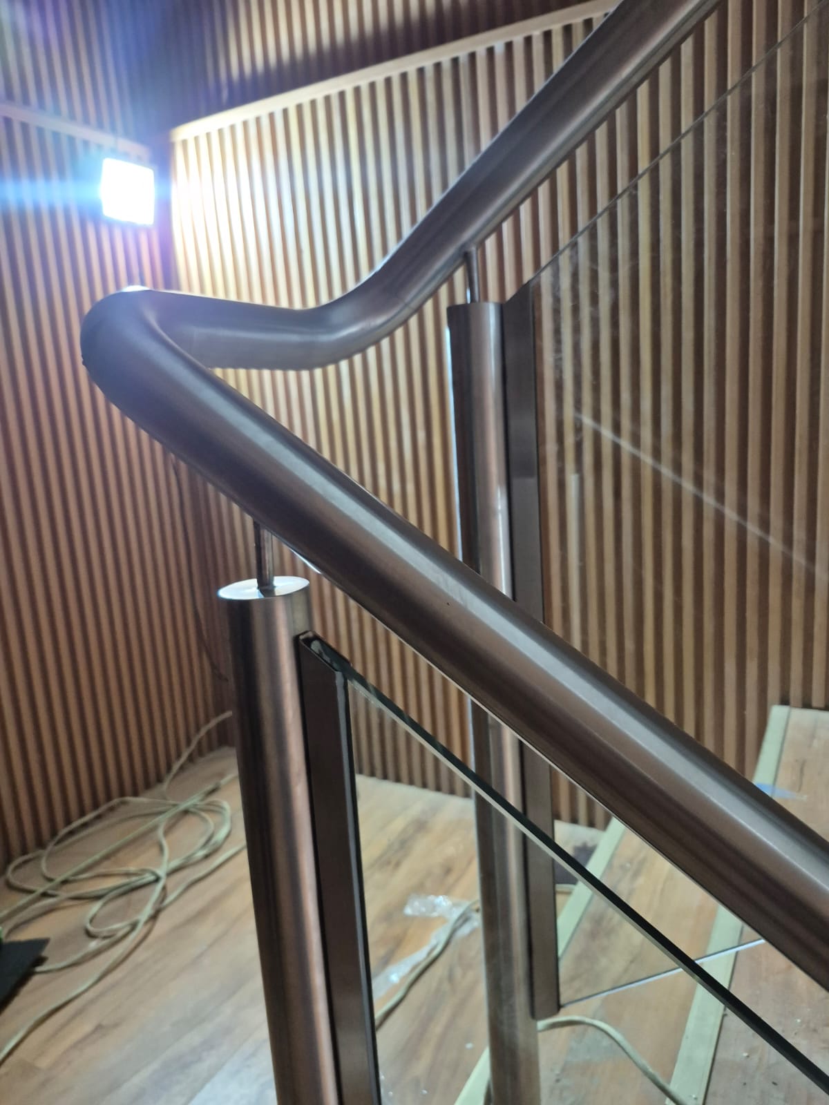 Baranda de escalera con vidrio y pasamanos color bronce